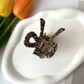 Macro shot of tortoise shell pattern bow hair claw clip on white ceramic tray - 6.5*5cm / Coffee Spotted