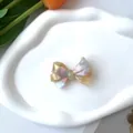 Primer plano de un pasador de lazo de acetato perlado con colores degradados de macaron - Clip de Pico de Pato Amarillo