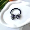 Detalle de un coletero con lazo y patrón de mármol morado en una bandeja con tulipanes - Cuerda para el Pelo Gris Púrpura