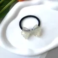 Detalle de una goma de pelo con lazo de acetato iridiscente y banda negra de alta elasticidad - Cuerda para el Pelo Blanco Iridiscente