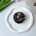 Detailed top view of a round acetate hair claw clip with a classic tortoiseshell pattern - Light Tortoiseshell