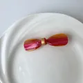 Acetat-Schleifen-Haarspange mit rot-orangefarbenem Farbverlauf und Goldakzenten - Gestreift