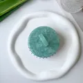 Top view of a marble-textured scalp massage brush with green handle and black bristles - Light Green