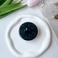 Close-up of a tortoiseshell acetate scalp massage brush on an artistic white tray - Dark Blue
