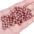 Pink natural stone loose beads for DIY jewelry making held in hand for scale - Diameter 6mm Hole Approx 1mm 10 Pcs/Pack / Natural Rhodonite
