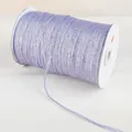 Detail of lavender glitter ribbon with metallic thread wound on white spool - Purple