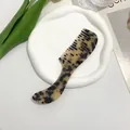 Detail of ergonomic tortoise shell acetate hair comb with leopard print on ceramic tray - Tortoiseshell