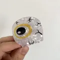 Dettaglio della molletta per capelli a occhio con texture in acetato marmorizzato - Bulbo Oculare Giallo