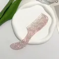 Pink acetate hair comb with mother-of-pearl texture on a white display tray - Transparent Pink