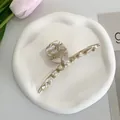 Close-up of white and brown tortoiseshell acetate hair claw clip on a minimalist tray - Cream Marble