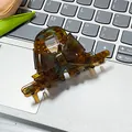Eleganter Haarklammer mit bernsteinfarbener Schildpatt-Schleife auf einem Laptop - Braun