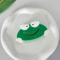 Lindo clip de pelo de rana verde de acetato, vista superior en bandeja blanca - Pinza Rana