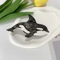 Detail van de orka vormige haarklem van acetaat met marmertextuur op decoratief bord - Zwarte Orka