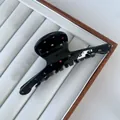 Close-up of black acetate hair claw clip with colorful rhinestones on a display tray - Bar Style / 12x4.5cm / Black