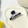 Cute black claw clip hair accessory with white 3D bow design for side hair styling - Bow