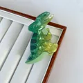 Detail of creative dinosaur hair claw with green gradient and pearlescent finish - T-Rex