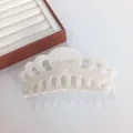 Macro-detail van een 14cm parelmoer witte acetaat haarklem met een hol kroonontwerp voor haar - Groot / Stralend wit
