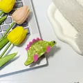Pinza per capelli a forma di dinosauro verde in acetato con pinne rosa sulla tastiera - Verde