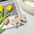 Set of two pink mushroom-shaped acetate hair claws with white polka dots on a laptop - Pink
