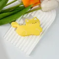 Detail of a bright yellow cat-shaped hair clip on a white tray with decorative tulips - 9.5cm x 5.5cm / Cat / Yellow