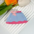 Dettaglio del fermaglio per capelli blu a forma di vestito con fiocco rosa su base - 9.5x5.5cm / Stile Gonna Blu