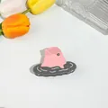 Detalle de pinza para el cabello con forma de delfín rosa hecha de acetato premium - Pez Globo Gris