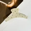 Grosse pince à cheveux crème à pois noirs posée sur un magazine de mode, vue rapprochée - Style Droit / 11.5*5cm / Beige