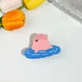 Detalle de una pinza para el pelo de delfín rosa en acetato brillante con ondas azules - Pez Globo Azul