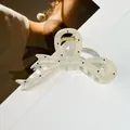Détail d'une pince à cheveux à pois noirs sur fond de magazine de mode élégant et moderne - Style Nœud Papillon / 12*6cm / Beige
