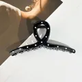 Détail d'une pince à cheveux noire à pois blancs avec un design ruban torsadé - Style en Forme de X / 13*6cm / Noir