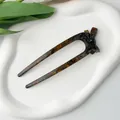 Detail view of U-shaped tortoiseshell acetate hair fork with a classic bow decoration - Maillard Style