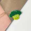 Nahaufnahme einer grünen Haarspange in Brokkoliform aus Acetat mit weißen Detailmustern - Blumenkohl