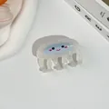 Gros plan d'une pince à cheveux méduse blanc nacré avec motif de visage souriant bleu - Méduse / 6.5x4cm / Milky blanc