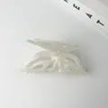 Macro shot of iridescent white butterfly hair claw clip with delicate cutout texture - Pearl White