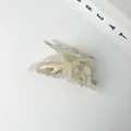 Detailed view of an iridescent green acetate butterfly hair claw clip with cutout wings - Green