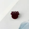 Macro detail of glossy burgundy antler hair claw clip on minimalist white background - Dark Red