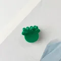 Detail of a glossy green acetate hair claw clip with a wavy design on a paper background - Green