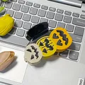Halloween claw clip featuring three colorful pumpkin faces on a laptop keyboard - Pumpkin