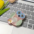 Haarklammer aus Acetat in Eulenform, Rosa mit grünen Flügeln, auf einer Tastatur - Rosa Eule