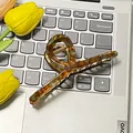 Große Vintage Schildpatt Haarklammer aus Bernstein und blauem Harz auf grauem Laptop - Wildgrün