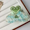 Dettaglio della pinza per capelli a cuore con acetato verde e strass scintillanti - Grande / Verde