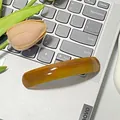 Fermaglio per capelli curvo in acetato ambra scuro su tastiera di un laptop - Caramello