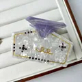 Detail of acetate hair claw with gold spiral patterns and purple rhinestone cross decoration - 8.5*5.5cm / Purple Diamond