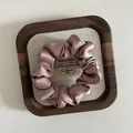 Detailed close-up of silky mauve satin scrunchie with soft folds on wooden tray - Small / Korean Pink