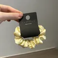 Detalle de un coletero de satén amarillo pálido con una etiqueta Made in Korea - Amarillo