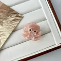 Mini octopus hair claw in translucent pink acetate with y2k design on white tray - Mini Pink Octopus