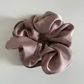 Close-up of elegant lotus pink satin scrunchie with silky folds on a wooden display - Large / Korean Pink