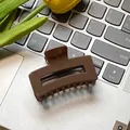 Minimalist square dark brown resin hair claw clip shown on a laptop keyboard - Brown 6cm