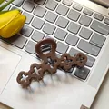 Elegant dark brown matte hair claw clip with hollow clover design on a laptop keyboard - Hollow Flower / 10cm / Brown