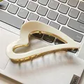 Elegant heart-shaped cream acetate hair claw clip with golden metal teeth on laptop keyboard - 11.5cm / Cream